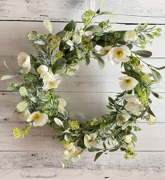 Silk floral wreath with white blooms and faux greenery on a grapevine wreath for your home and office 